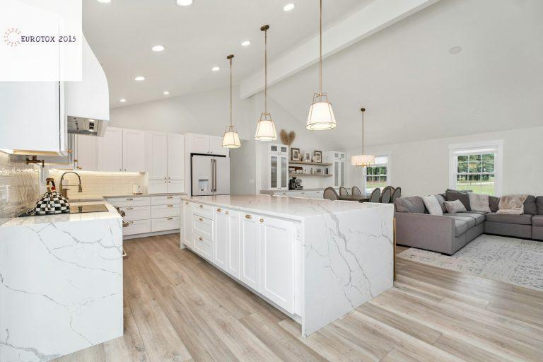 a large kitchen with a center island and marble counter tops
