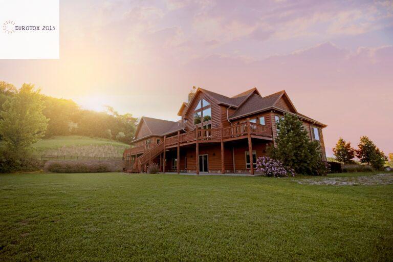 brown wooden house with green grass field