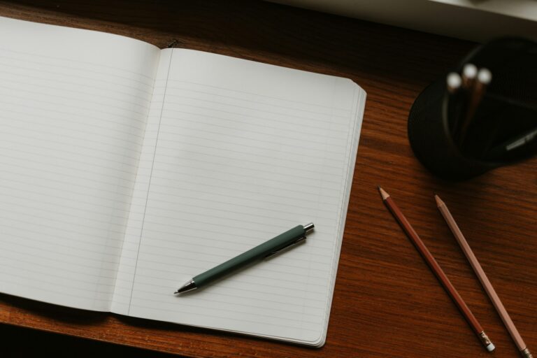 Cuaderno abierto y bolígrafo sobre una mesa, para escribir a la redacción de Eurotox 2015